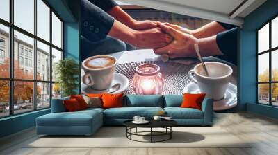 clasped hands of a loving couple over a table in a cafe with two symbolic cups of coffee. For him - empty, everything is decided, for her untouched, there are doubts Wall mural