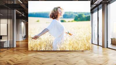 smiling happy woman in wheat field Wall mural