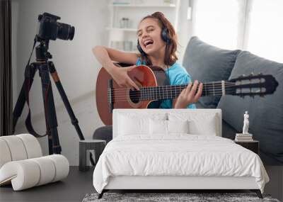 Child guitarist making video lessons and tutorials for internet vlog website classes. Wall mural