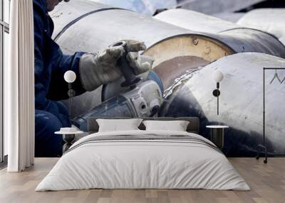 Construction worker cutting the metal pipe with a anglegrinder. Wall mural