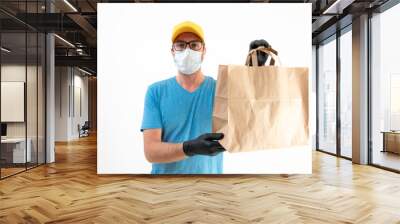 Delivery guy with protective mask holding paper bag with groceries. Wall mural