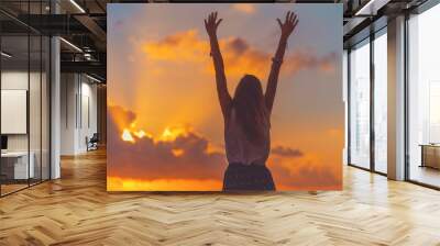 Girl with arms wide open enjoying sea / ocean scenery in sunset. Wall mural