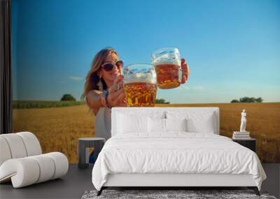 Happy girl holding beer glass in a big wheat-field. Wall mural