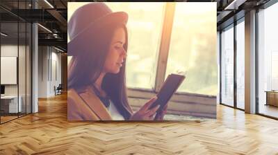 Teenager reading book in a rustic room. Wall mural