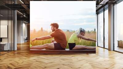 Young adult sporty couple working out outdoors in urban surroundings. Wall mural