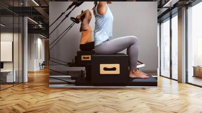 Young women exercising in a gym on pilates machines. Wall mural