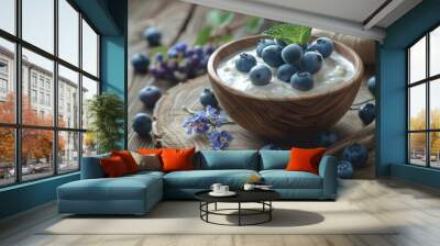 A bowl of blueberries and yogurt on a wooden table. The blueberries are scattered around the bowl and some are in the center Wall mural