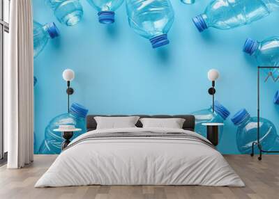 A row of plastic water bottles are scattered across a blue background. The bottles are all clear and blue, and they are arranged in a circular pattern. Concept of waste and environmental impact Wall mural