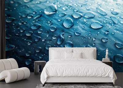 The image is of a blue surface with many small drops of water on it. The drops are scattered all over the surface, creating a sense of movement and fluidity Wall mural