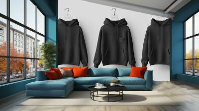 Three black hoodies on hangers. Perfect for showcasing designs, logos, or branding. Wall mural