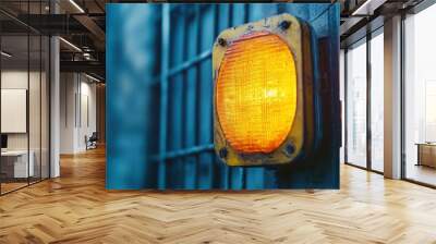 A yellow light is lit up on a metal pole Wall mural