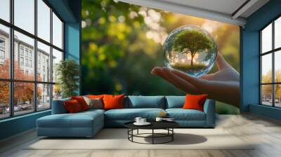 Hand Holding Glass Sphere with Tree Inside Wall mural