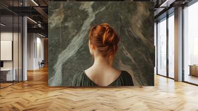 Back of redhead woman standing in front of abstract wall with vintage aesthetic Wall mural