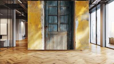 Old wooden door on a yellow wall with sunlight shining through the window panes. Wall mural