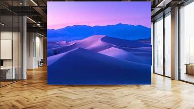 Purple and blue sunset over sand dunes in the desert with mountains in the background Wall mural