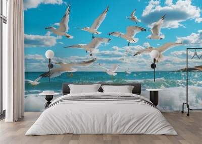 Seagulls flying over ocean waves with blue sky and clouds in the background Wall mural