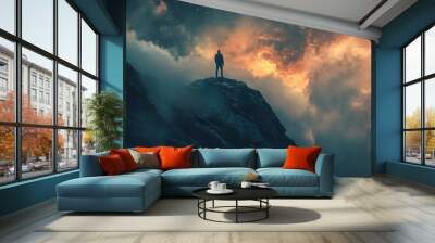 Silhouette of a man standing on a mountain top against a dramatic sunset sky with stars Wall mural