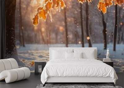 Winter sunrise in a snow covered forest with golden leaves hanging from a tree branch Wall mural