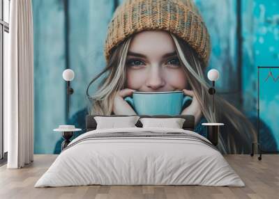 Young woman smiling with cup of coffee in front of blue wooden wall Wall mural