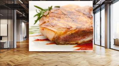 juicy piece of fried pork chop with rosemary and tomato sauce on a white plate close-up Wall mural