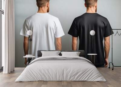 Two men wearing white and black t-shirts standing back to back. Wall mural