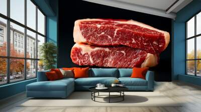 Two raw beef steaks stacked on a dark surface, ideal for culinary presentations. Wall mural