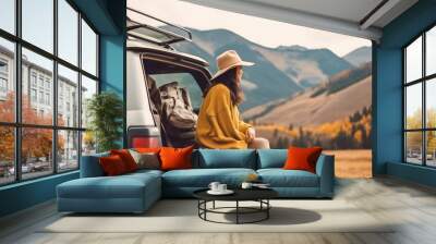 View of young woman traveler sitting on hatchback car , Happy woman traveler looking at mountain background , Created with Generate Ai Technology Wall mural