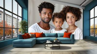 Happy young family of three posing in white attire for indoor portrait Wall mural