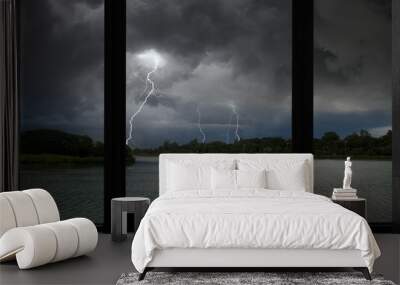 Scared lightning strikes over the forest and river Wall mural