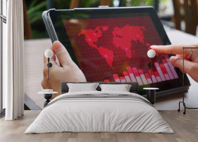 Hand hold tablet which have red theme world map on the screen. Wall mural