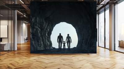 A silhouette of a family, including a child, standing hand in hand at the entrance of a dark tunnel, symbolizing togetherness and adventure in a serene outdoor setting. Wall mural