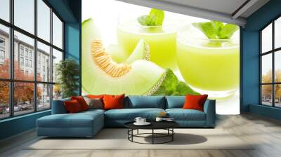 Refreshing melon drinks with mint leaves, served in glassware alongside a sliced melon. Perfect for summer beverages. Wall mural