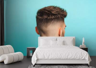 Stylish haircut on a young man's head, showcasing detailed fade and texture against a vibrant turquoise background. Wall mural