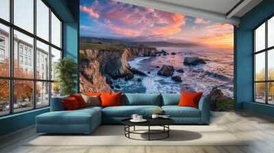 A beautiful sunset over the ocean with a rocky shoreline Wall mural