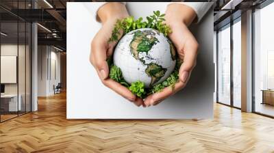 A person gently holds a small globe surrounded by green plants, symbolizing care for the environment and sustainability. Wall mural