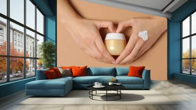 A jar of hand cream on a light, beige background. Wall mural