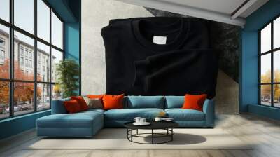 Black folded sweatshirt on two tone background Wall mural