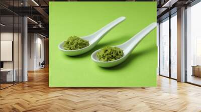 Ceramic spoons with wasabi on green background Wall mural