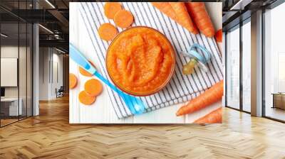 Composition with carrot puree on white wooden background. Baby food Wall mural