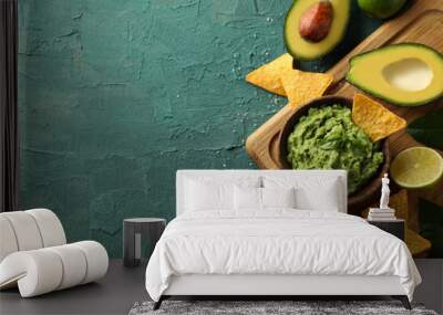 Concept of tasty eating with bowl of guacamole on green textured background Wall mural