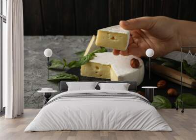 Concept of tasty eating with female hand hold camembert cheese Wall mural