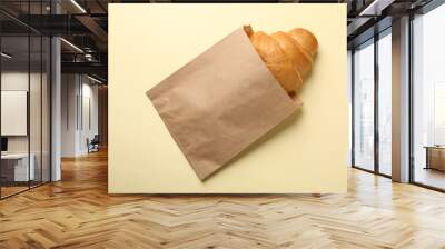 Craft paper bag with croissant on beige background, space for text Wall mural