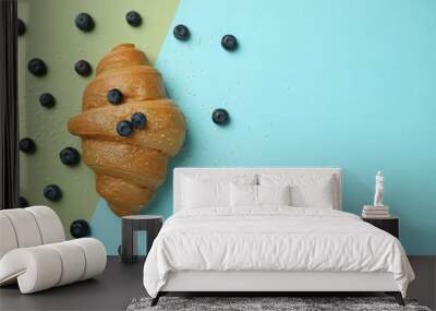 Croissant and blueberry on two tone background Wall mural