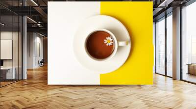 Cup of chamomile tea on two tone background, top view Wall mural