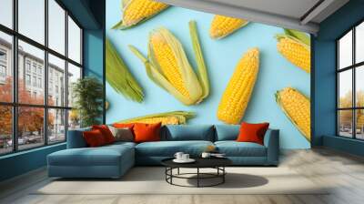 Flat lay with fresh raw corn on blue background, top view Wall mural