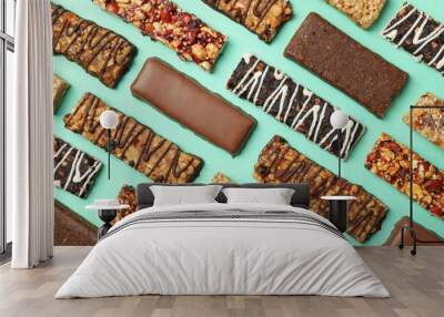 Flat lay with tasty granola bars on mint background, top view Wall mural