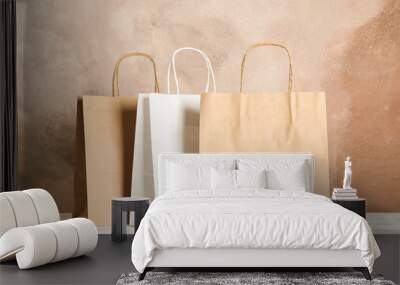 Paper bags on white table against brown background, copy space Wall mural