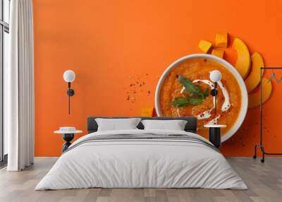 Pumpkin cream soup on orange background, top view Wall mural