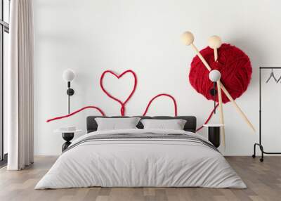 Red ball of yarn and knitting needles on white background Wall mural