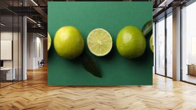 Ripe lime on green background, top view Wall mural